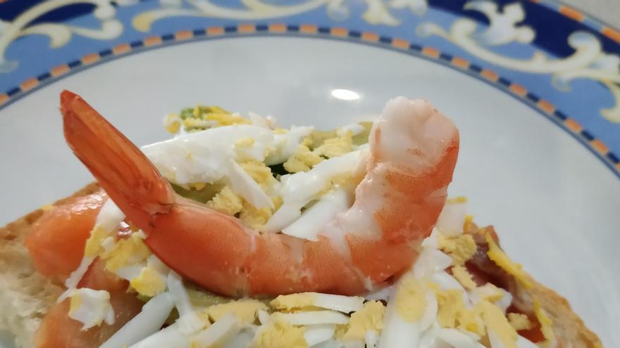 Montadito de salmón ahumado con aguacate, huevo duro y gamba.