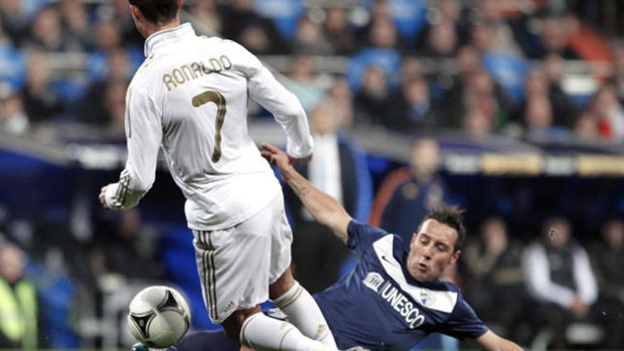 Cristiano Ronaldo intenta controlar un balón con ante la oposición de Santi Cazorla en el partido de Copa disputado el pasado 3 de enero de 2012.