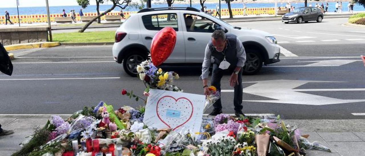 Un hombre coloca flores en recuerdo a Samuel Luiz, en el lugar de la agresión mortal.   | // CARLOS PARDELLAS