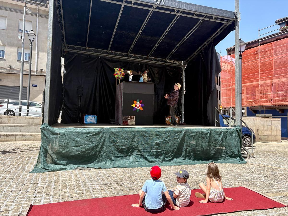 Tres niños en la sesión de títeres programada en la plaza de Requejo de Mieres por las fiestas de San Xuan