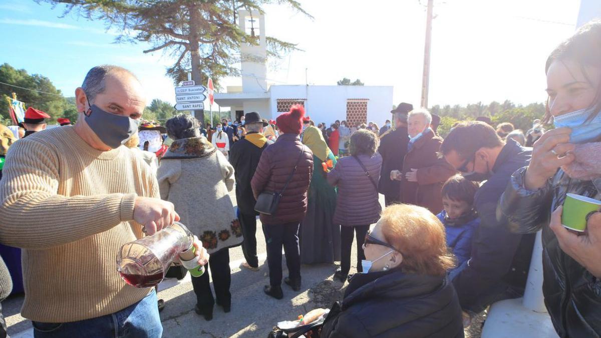 Un miembro de la asociación de vecinos del pueblo sirve vi pagès a los allí presentes