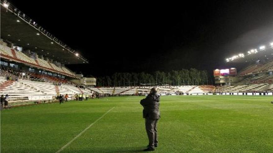 Un guàrdia observa com fallen un bon grapat de focus a la coberta d&#039;una de les tribunes de l&#039;estadi de Vallecas ahir al vespre.