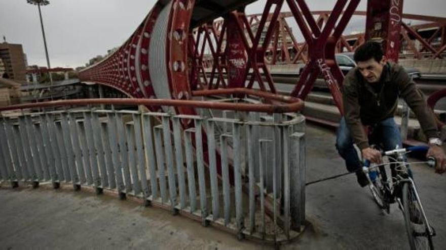 Un joven aprovecha la infraestructura del Puente Rojo de la Gran Vía para cruzar hacia el barrio de San Blas.