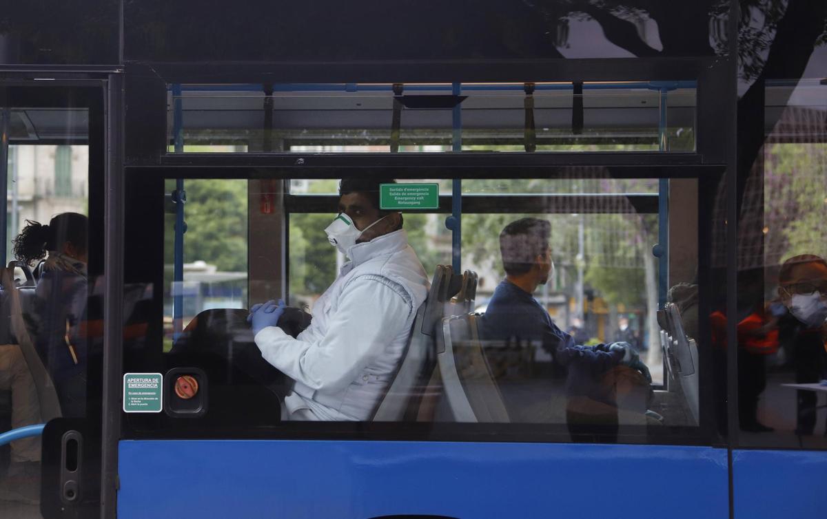 Viajeros con mascarilla en un autobús de Madrid.