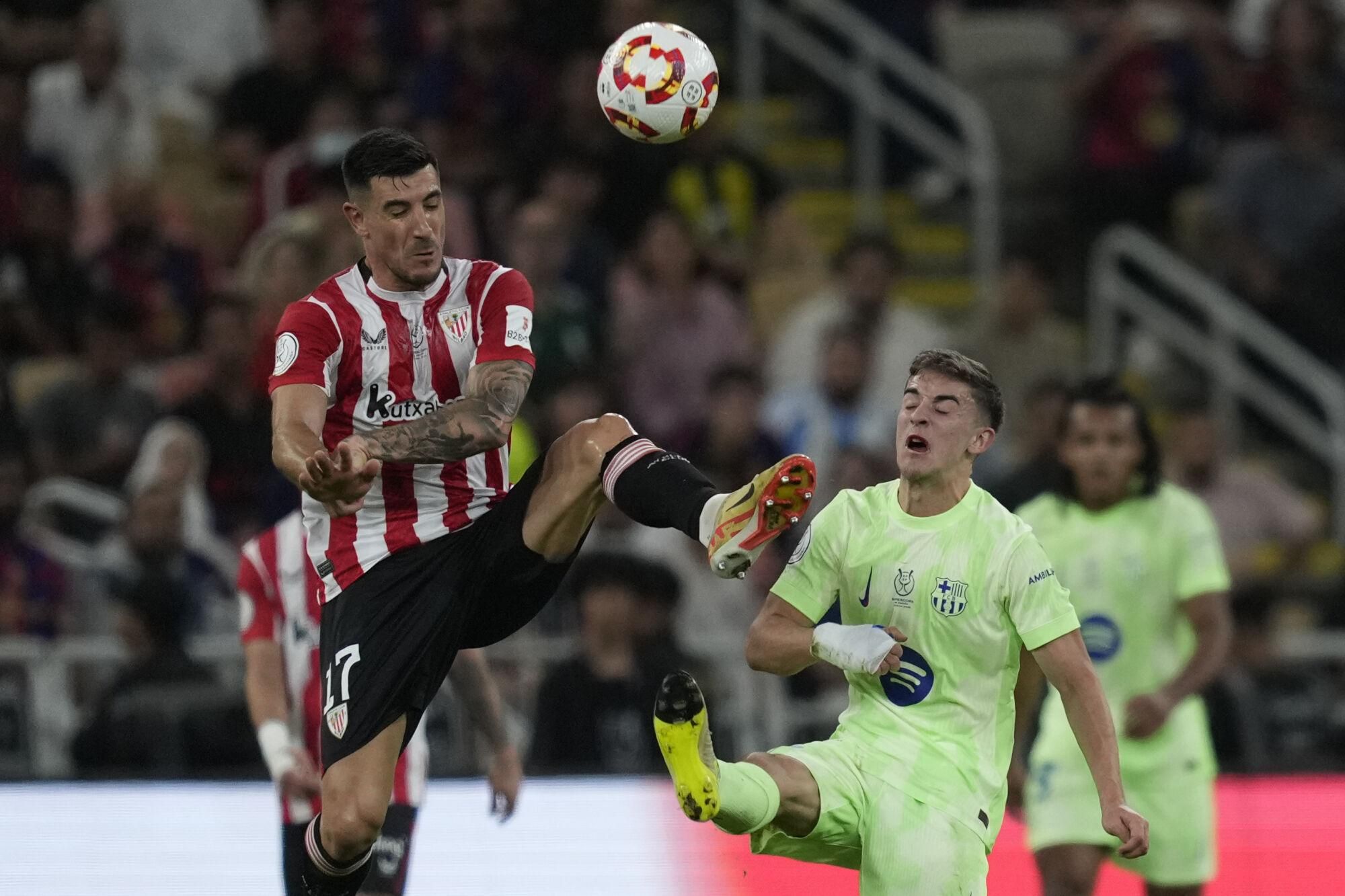Athletic Bilbao's Yuri Berchiche, left, and Barcelona's Gavi fight for the ball during the Spanish Super Cup semifinal match between Athletic Bilbao and Barcelona in Jeddah, Saudi Arabia, on Wednesday, Jan. 8, 2025. (AP Photo/Altaf Qadri). EDITORIAL USE ONLY / ONLY ITALY AND SPAIN