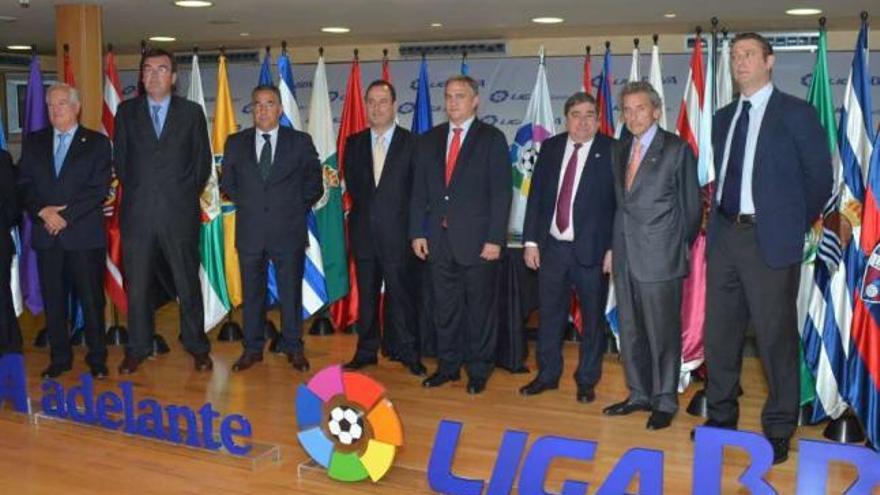 Lendoiro coloca la bandera del Dépor ayer en el acto de bienvenida de los clubes a Primera y Segunda. / l. o.