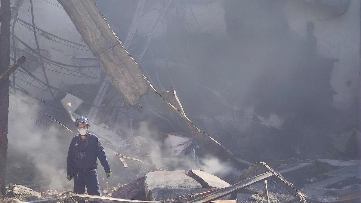 Un agente, en un escenario devastado por el fuego.