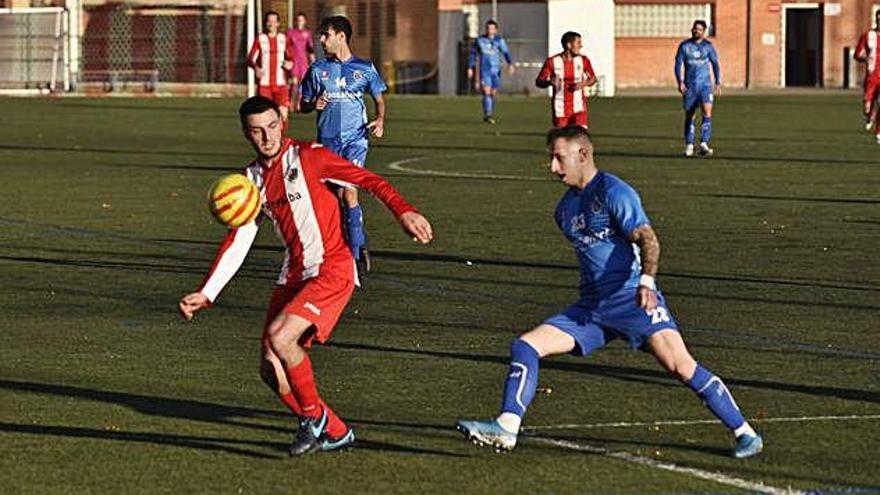 Joel Canals protegeix la pilota sota la marca del defensor del Calaf