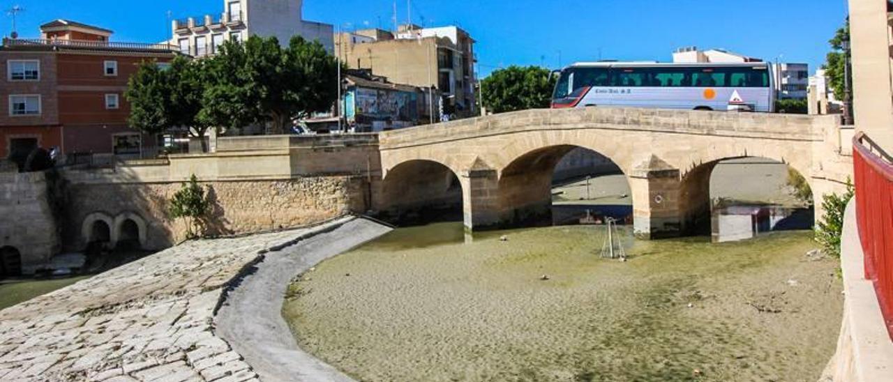 El río muestra una desoladora imagen a su paso por el casco urbano de Rojales sin apenas agua y con el cauce lleno de sedimentos.