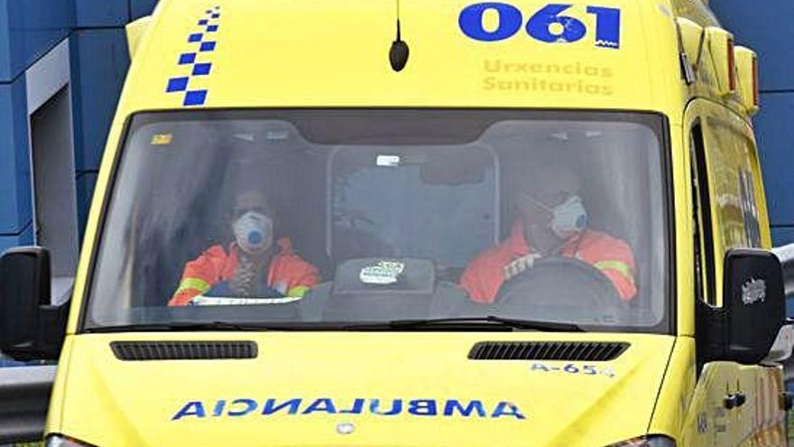 Un conductor y una sanitaria con mascarillas, en una ambulancia en los accesos de las Urgencias del Chuac.