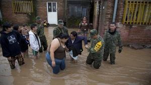 Uns soldats ajuden una dona a sortir de casa seva, inundada, per portar-la a un refugi, ahir.