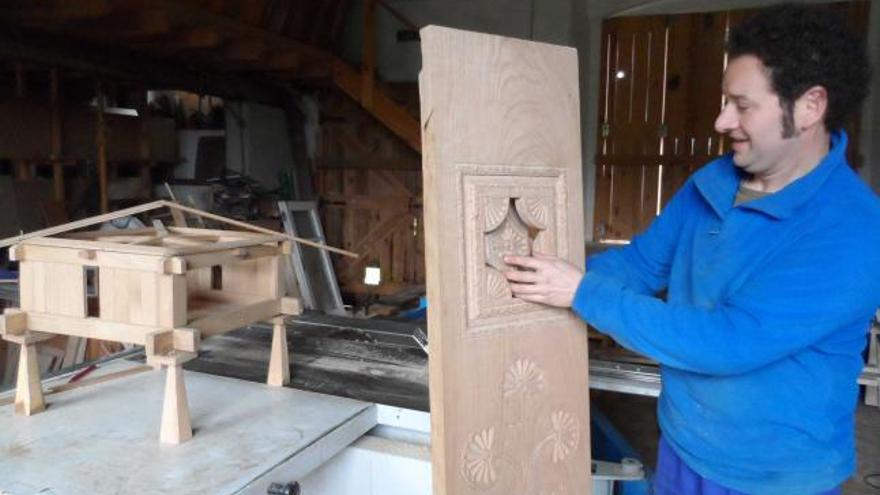 Julio César Zapico, abriendo la ventana de una colondra; a la izquierda, un hórreo en miniatura, en Piedeloro.