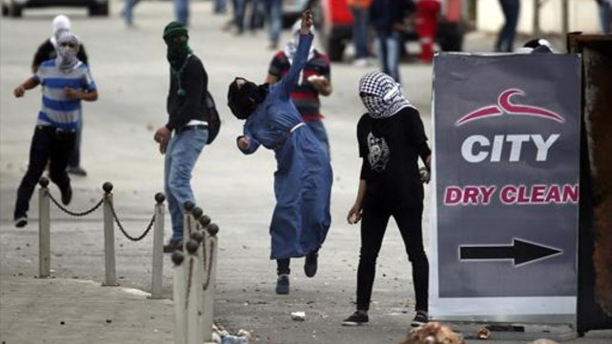 Manifestantes palestinos lanzan piedras ayer a las fuerzas israelís en Beir El, cerca de Ramala.