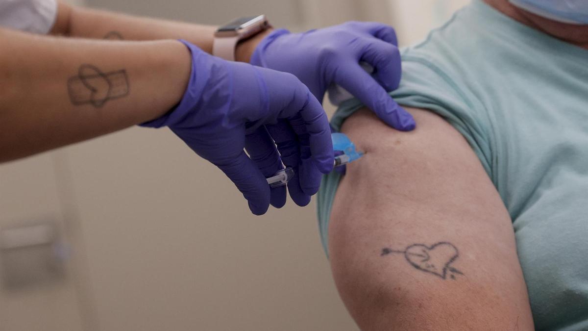 Una profesional sanitaria pone una vacuna en un centro de salud.