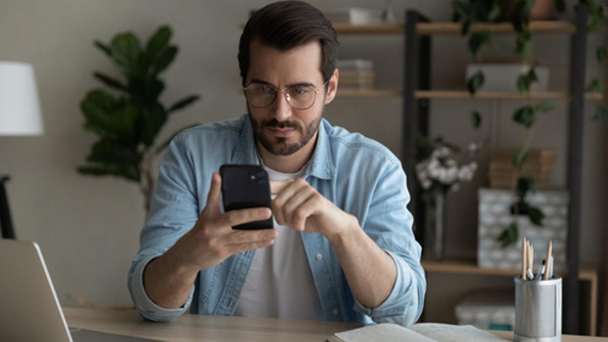 Un joven consulta datos de su hipoteca en su smartphone.