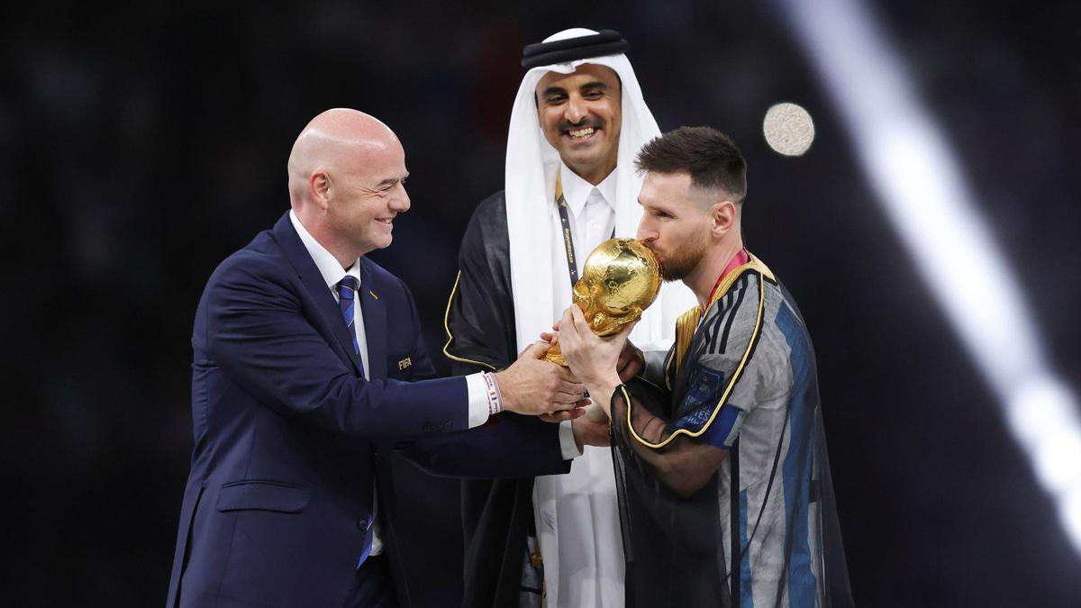 Messi recibe la copa de campeón mundial de Infantino, presidente de la FIFA, y en presencia de Al Thani, emir de Qatar.