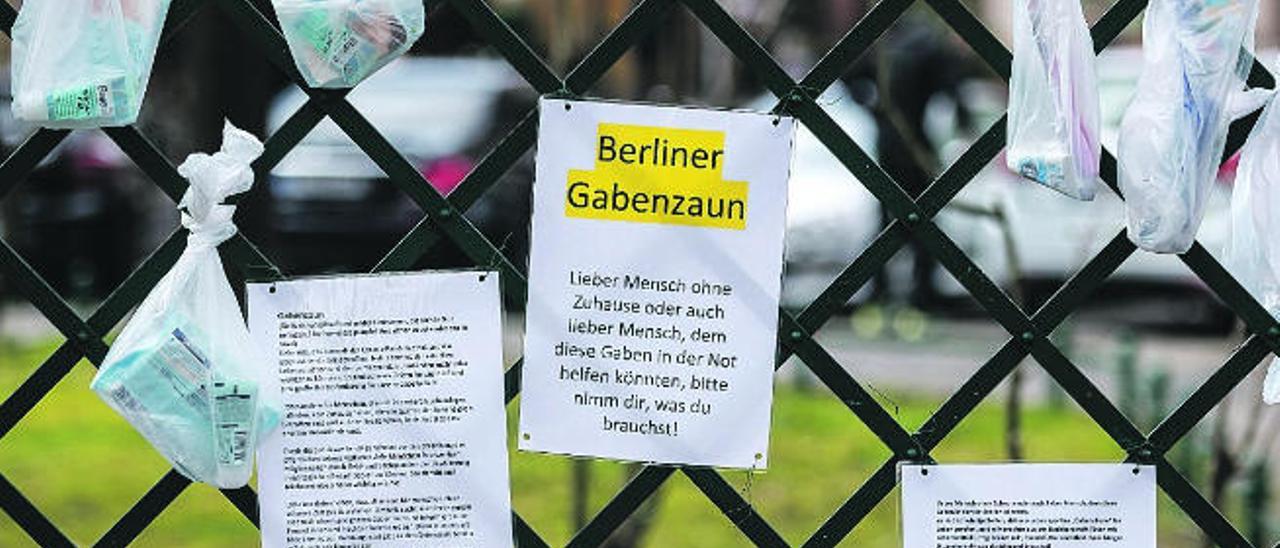 Bolsas con productos de higiene y alimentos colgadas por ciudadanos en Berlín para los sin techo.