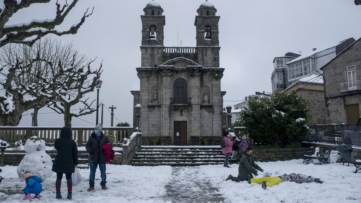 Adultos y niños disfrutando de la nieve en Castro Caldelas, en diciembre de 2020.