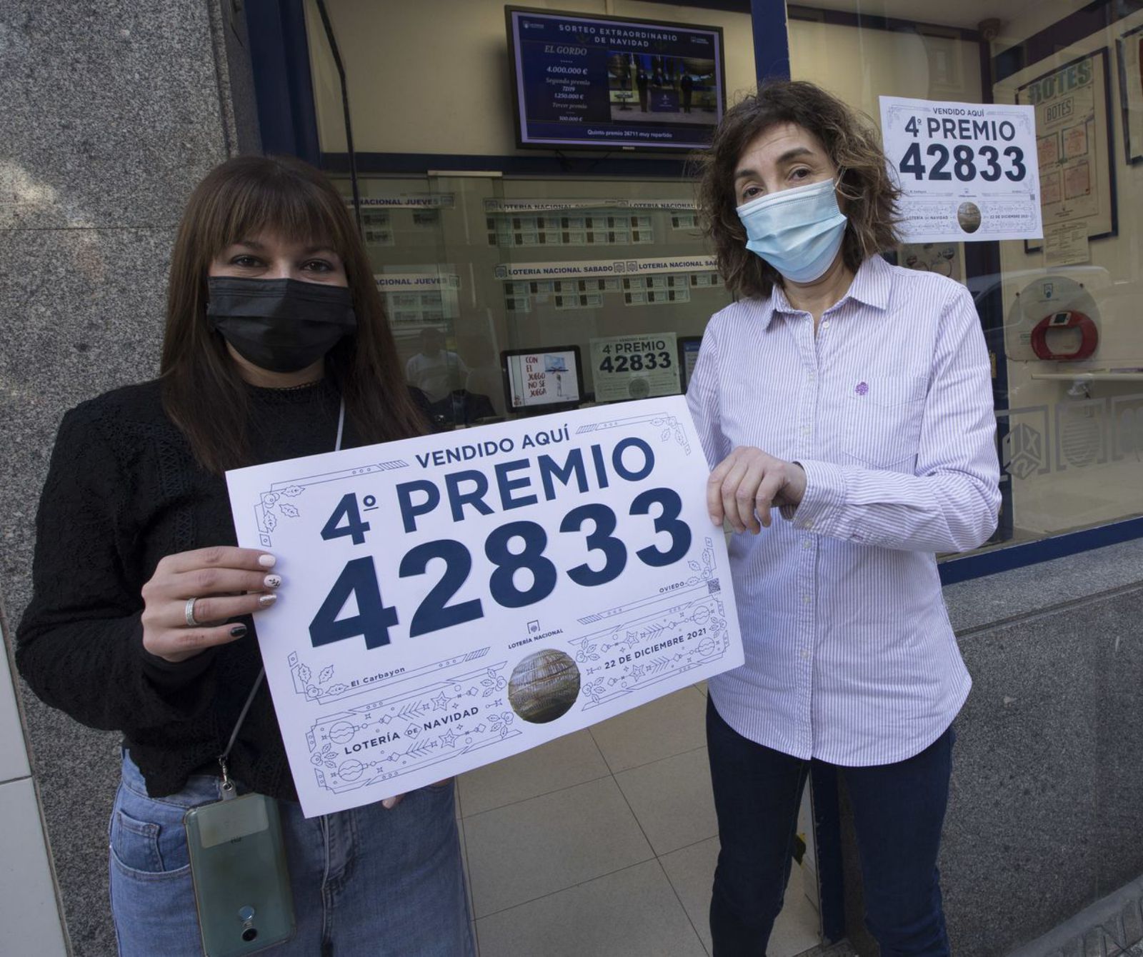 Natalia Francisco, a la izquierda, y Dolores Moraño, posando con el cartel del premio  en Valentín Masip. |