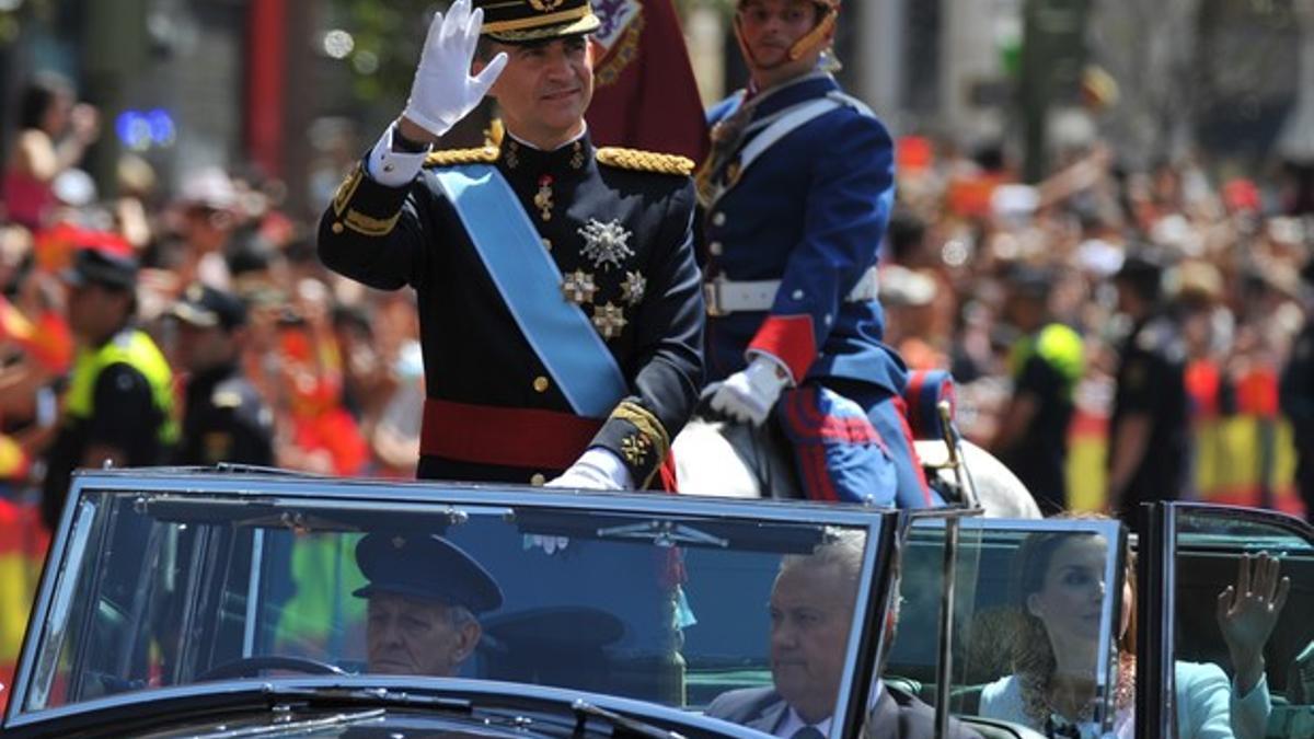 Felipe VI, de pie en el coche descubierto, durante el recorrido hacia el Palacio Real.