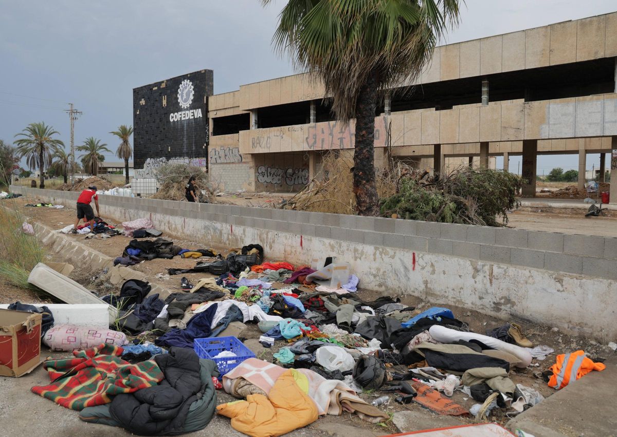 UIno de los migrantes desalojados rebusca entre las ropa usada.