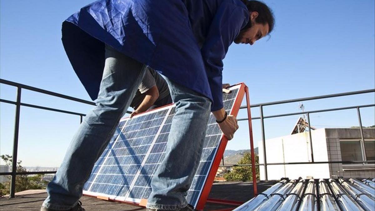 Un hombre instala placas fotovoltaicas.