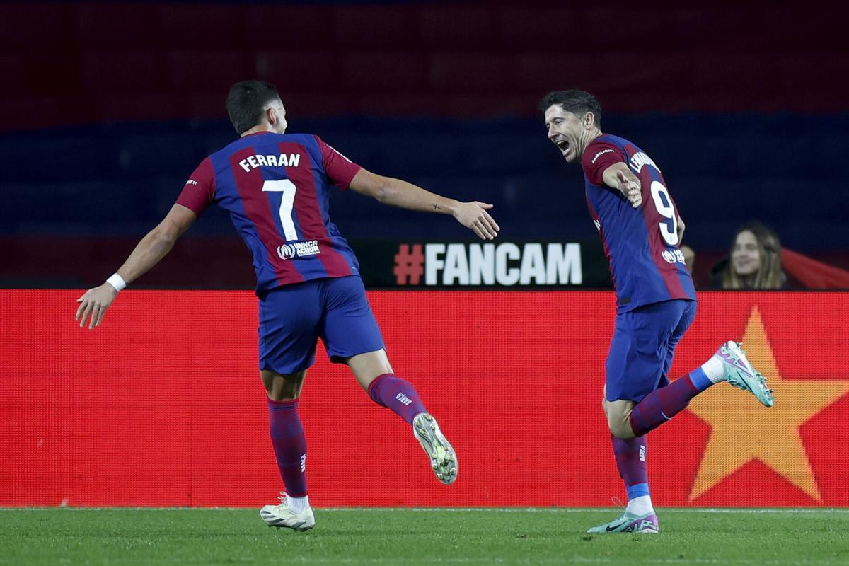 FC Barcelona's striker Robert Lewandowski (R) celebrates with teammate Ferran Torres (L) after scoring the 2-1 goal during the Spanish LaLiga soccer match between FC Barcelona and Deportivo Alaves, in Barcelona, Spain, 12 November 2023. EFE/ Alberto Estevez