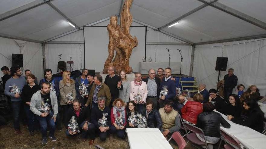 Los premiados posan delante del monumento, que simboliza a un voluntario que vierte agua sobre las llamas.