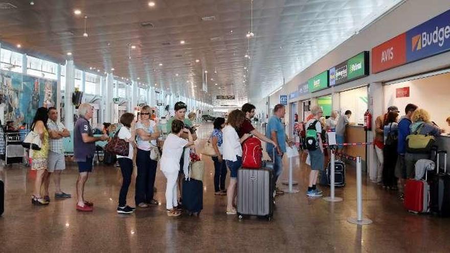 Colas de viajeros en el aeropuerto de Peinador, ayer. // Marta G. Brea