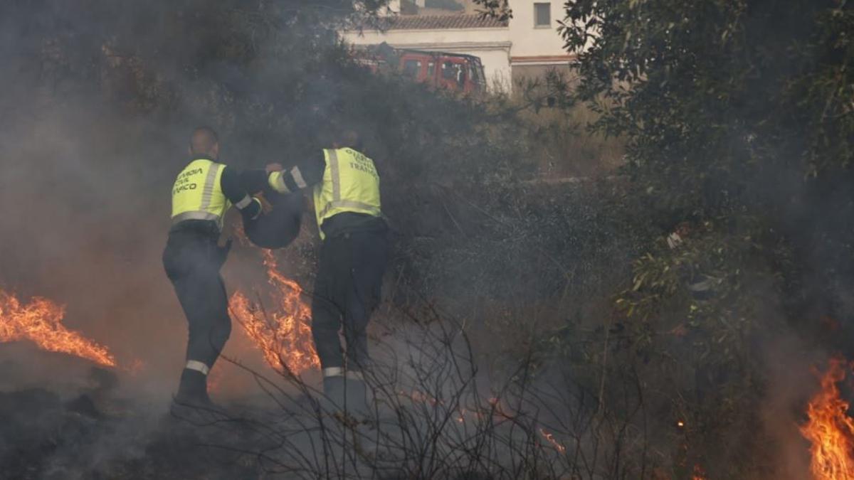 Dos agentes de la Guardia Civil apagan como pueden las llamas en Ador.