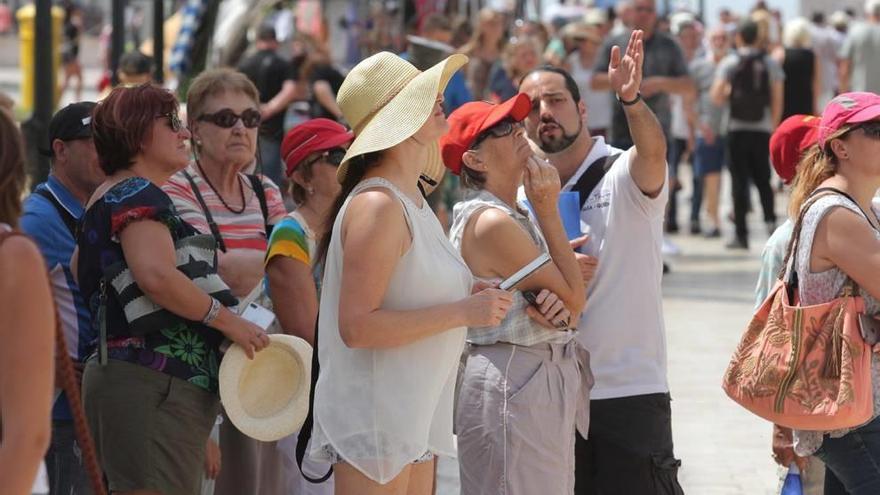 Un grupo de turistas escucha las explicaciones de un guía en Cartagena.