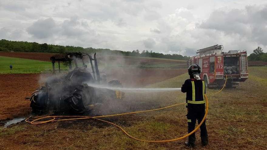 Los bomberos echan agua sobre un tractor incendiado la semana pasada en la localidad de Matellanes.