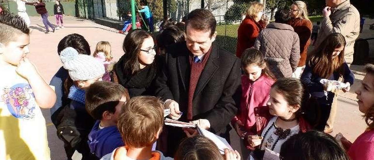 Abel Caballero firmando, ayer, autógrafos a un grupo de escolares del colegio Párroco Don Camilo. // FdV