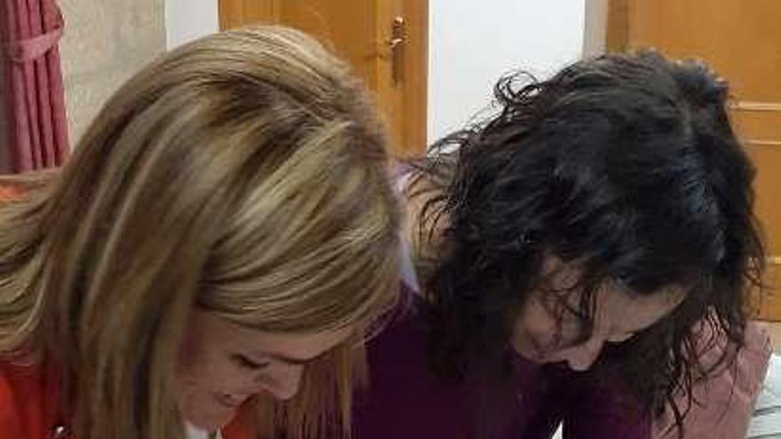 Digna Rivas (PSOE) y Susana Couñago (AER) firman el pacto para la investidura. // FdV