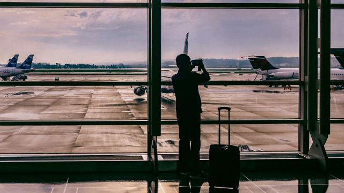 Un pasajero fotografía a un avión en la puerta de embarque de su avión.