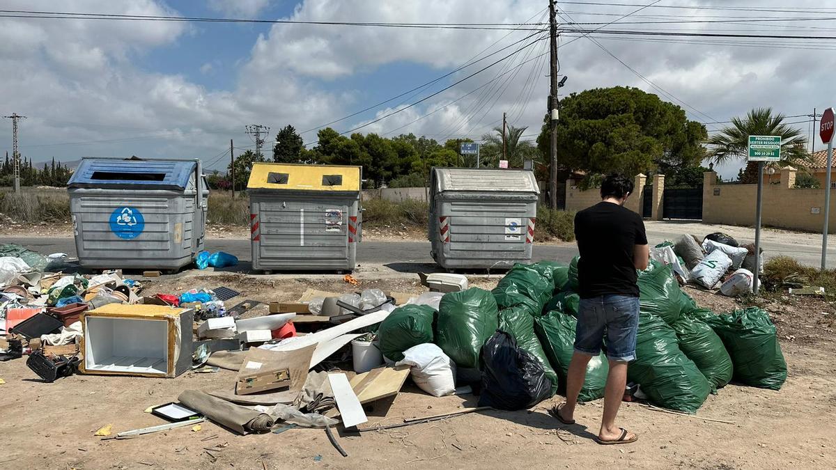 Un vecino mira la basura acumulada en un solar en la partida Sol y Luz en San Vicente.