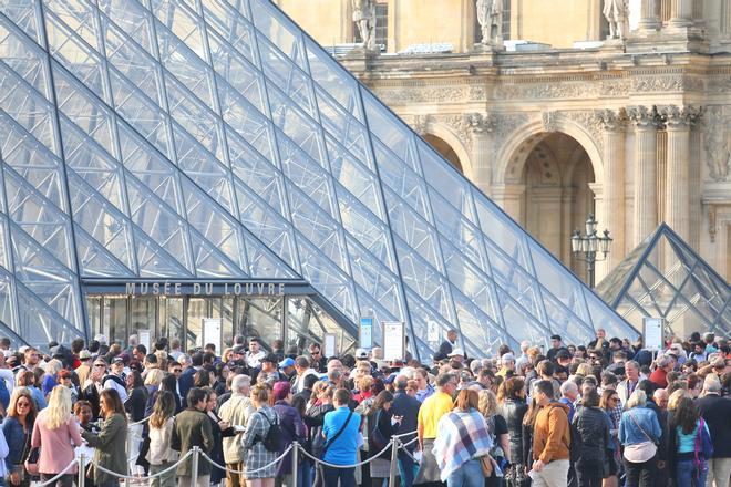 Viajeros haciendo cola para entrar al Museo del Louvre.