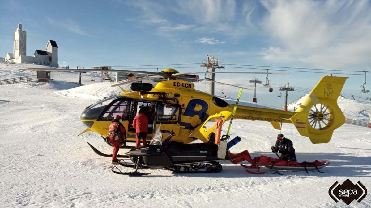 Sanitarios trasladan a la herida al helicóptero, en la zona alta de Pajares.