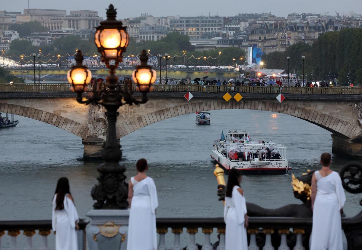 Participantes durante el desfile flotante pasan bajo el Pont des Invalides en el río Sena durante la inauguración de los Juegos Olímpicos de París 2024