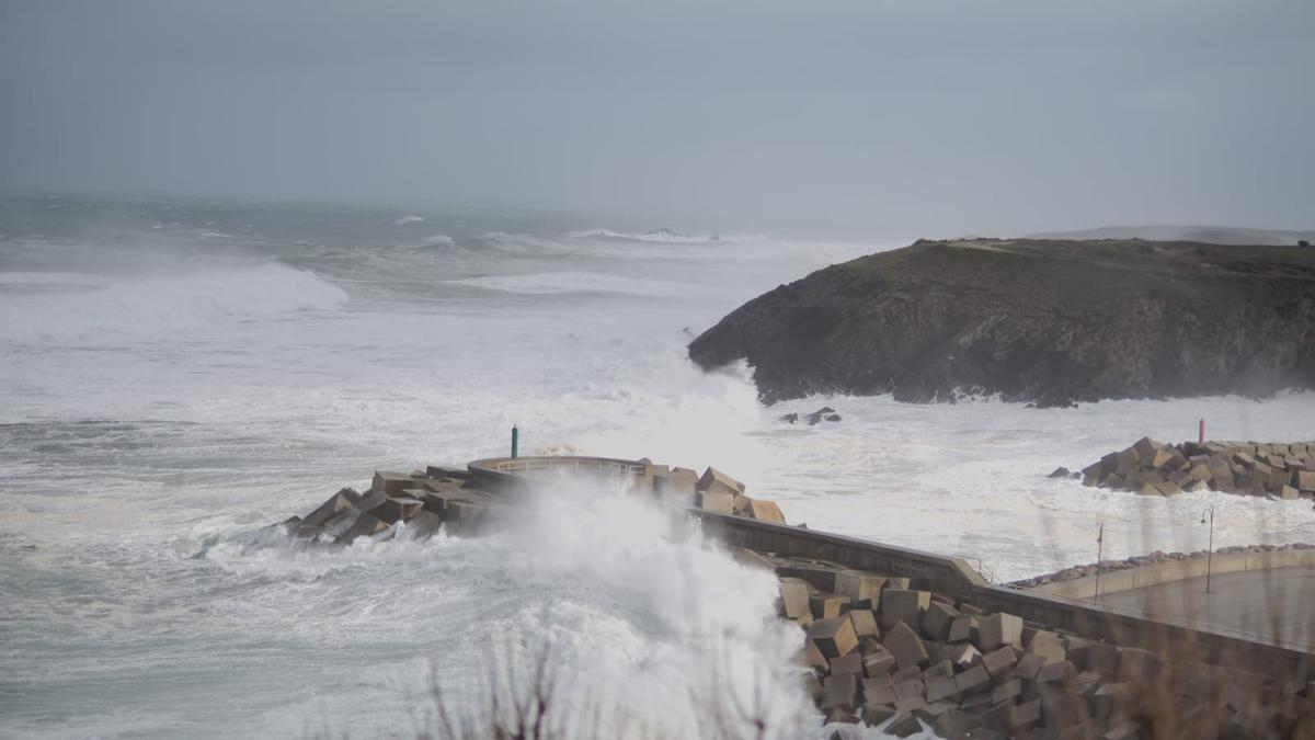 Una imagen del espigón de Puerto de Vega cubierto por las olas