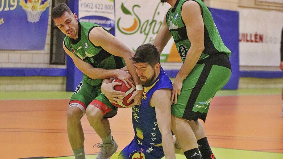 Denis Tokaev lucha por el balón con dos defensores del Calpe. | ALFONSO SALDAÑÁ