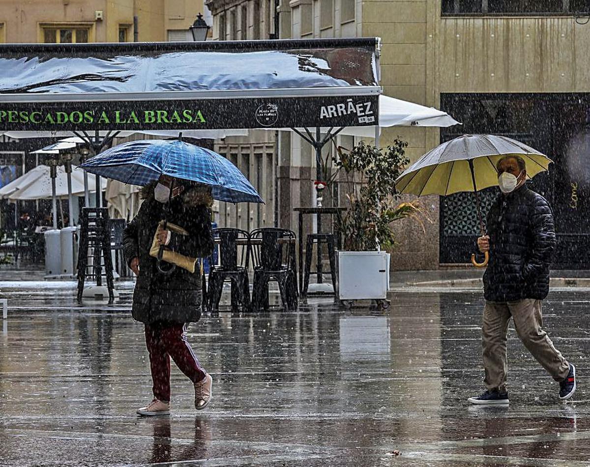 Dos personas se protegen de la lluvia el jueves pasado. | ANTONIO AMORÓS