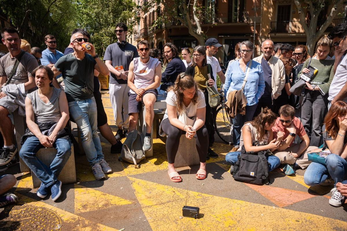 Vecinos de Barcelona se reúnen a escuchar la radio analógica para informarse sobre el apagón Vecinos de Barcelona se reúnen a escuchar la radio analógica para informarse sobre el apagón