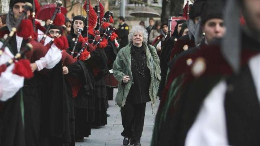 Ada Yonath camina hacia el edificio Politécnico entre los músicos de la Real Banda de Gaitas. A la derecha, firmando el libro de visitas del Concello, con el alcalde.  // Iñaki Osorio