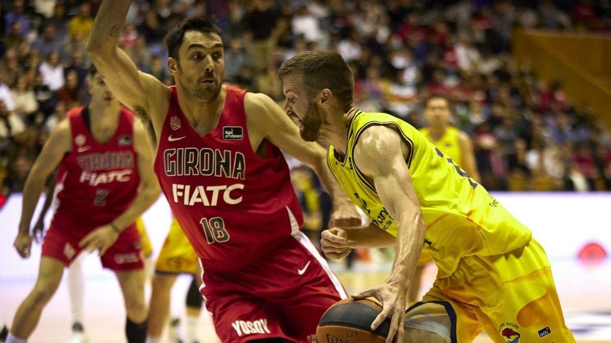 John Shurna intenta zafarse de la defensa de Pierre Oriola en el choque del Granca ante el Girona