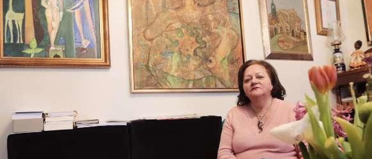 Conchita Fernández, en su casa de Oviedo, con tres obras de Juan Falcón a sus espaldas.