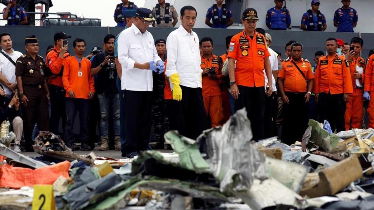 El presidente indonesio, Joko Widodo (centro), inspecciona algunos de los restos del avión de Lion Air siniestrado.