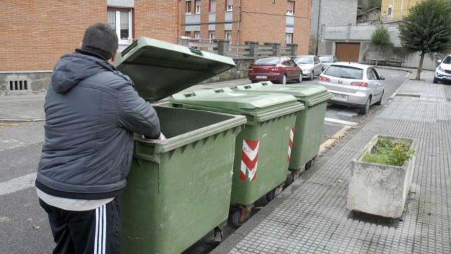 Un vecino de Ujo, ayer, depositando basura en uno de los nuevos contenedores.