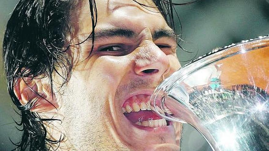 Rafa Nadal da su tradicional «mordisco» al trofeo romano.