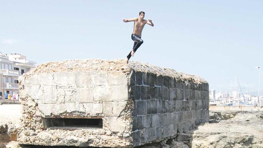 Un muchacho inicia un espectacular clavado desde el techo del búnker situdo junto al puerto.